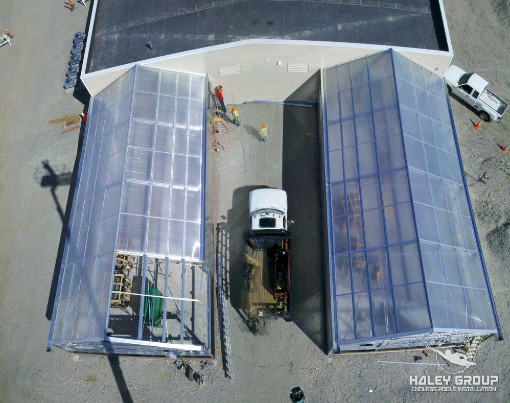Aerial view of twin lean-to greenhouses against a building