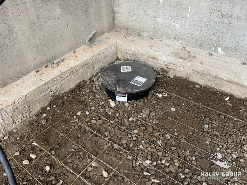 Gravel base with rebar grid and a sump basin set in the corner of the crawlspace